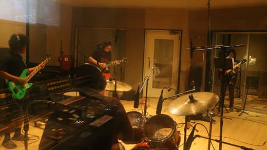 The full band tracking, seen from behind the mixing console through the control room glass