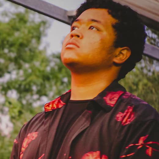 Jacoby Cantu in a rose-print shirt, looking up past the camera