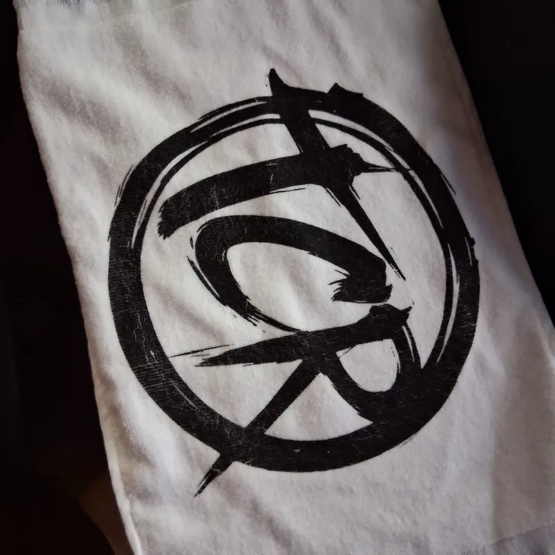 White fringed rally towel with a large black TCR seal print